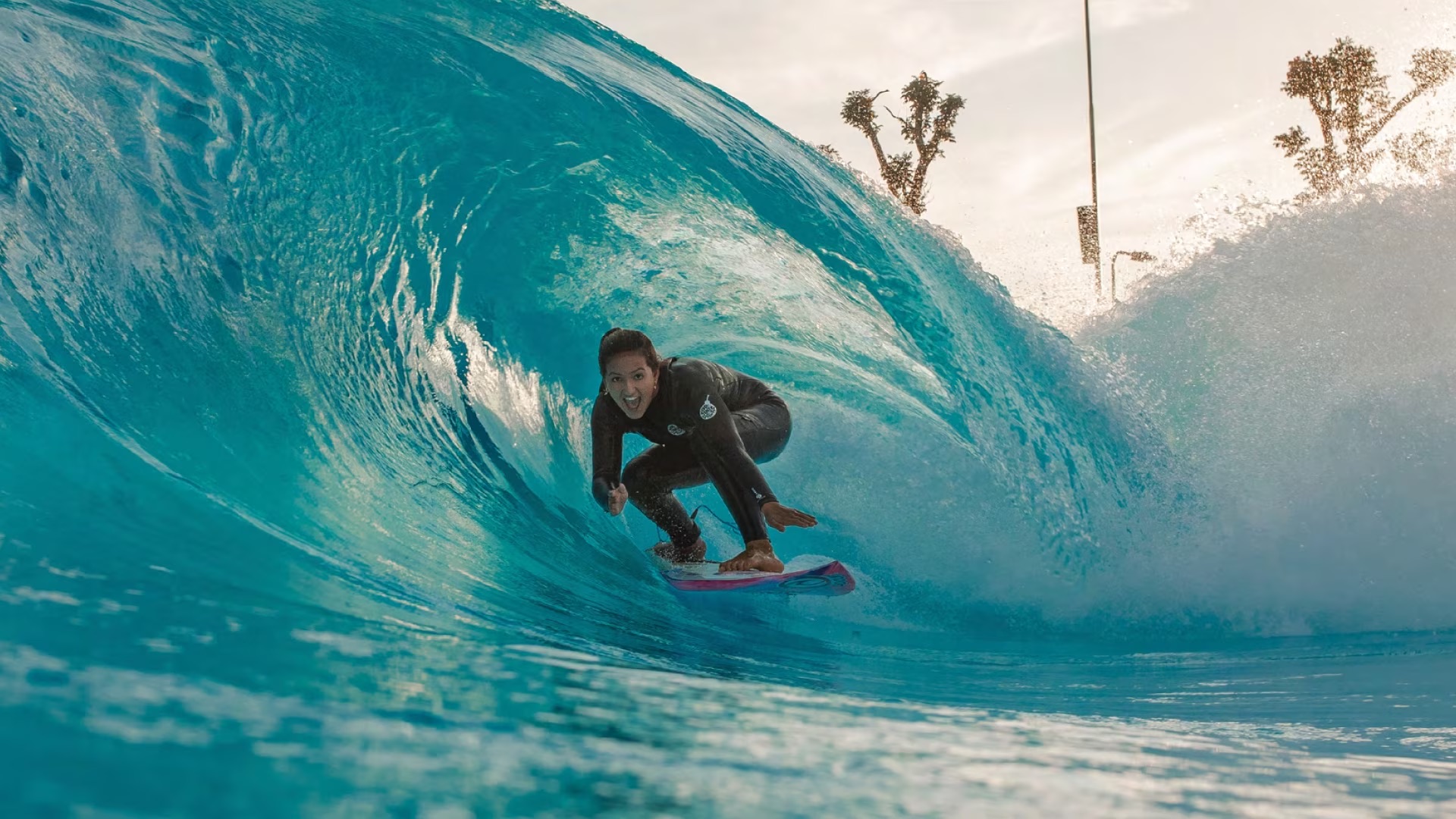 Surfista dentro de una ola turquesa en la piscina de olas de El Nido